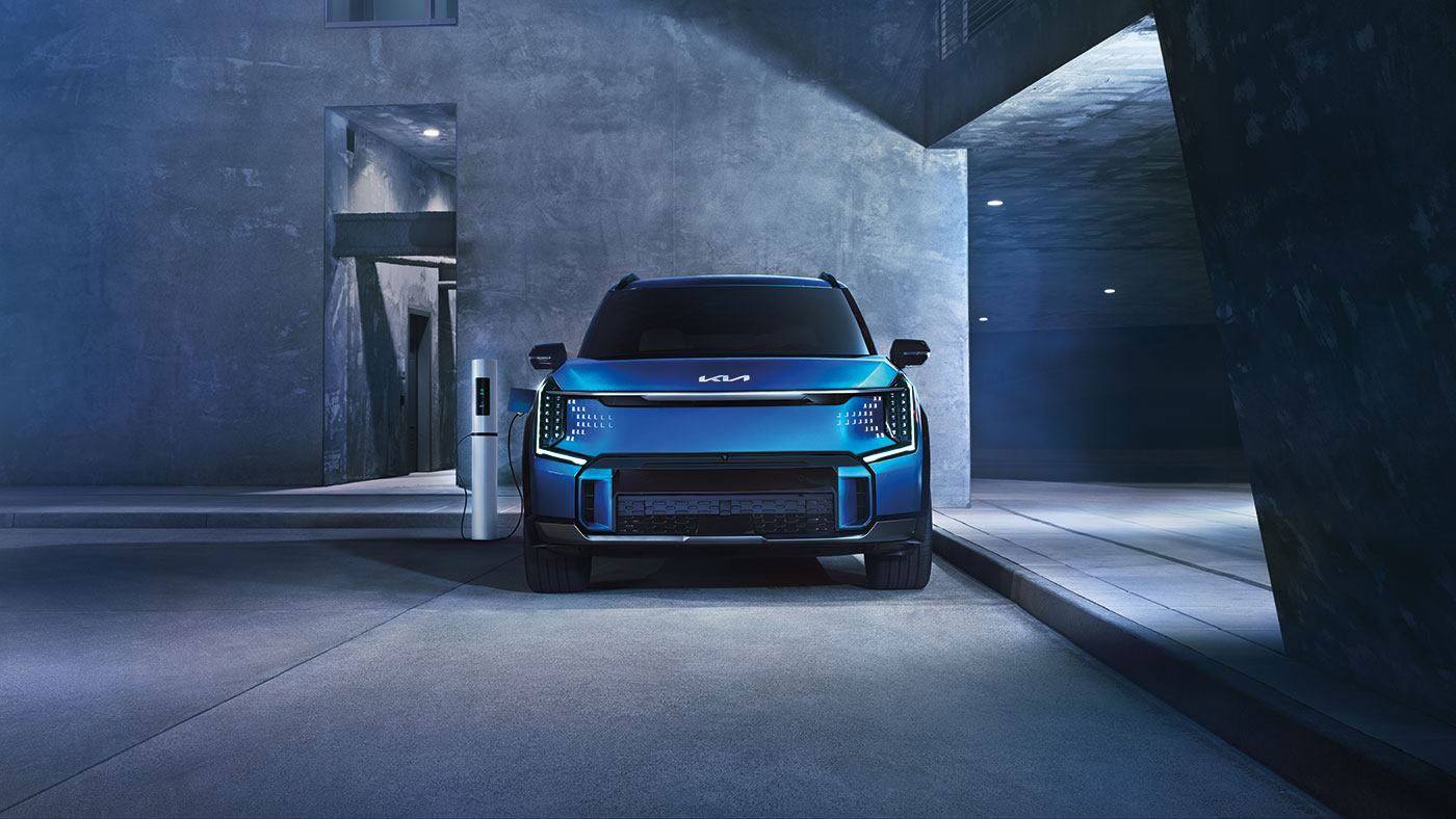 Kia all-electric SUV charging at a public fast-charging station