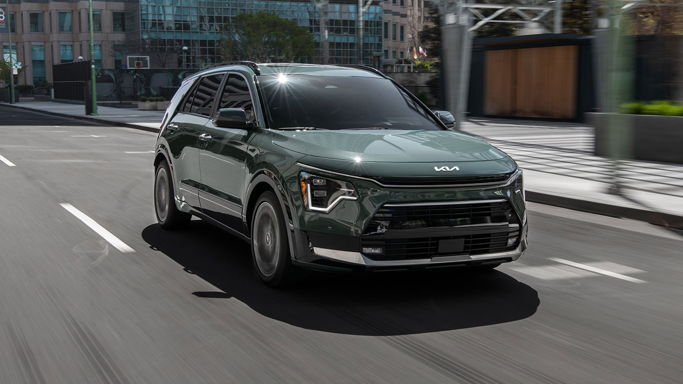 Front exterior of Niro Hybrid SX in Cityscape Green driving.